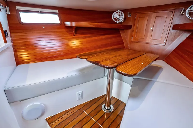 Tumalum Yacht Photos Pics Interior of 2023 MJM 35 boat with wooden table and seating area.