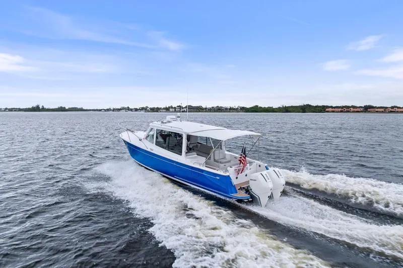 Tumalum Yacht Photos Pics 2023 MJM 35 boat cruising on open water under a clear blue sky.