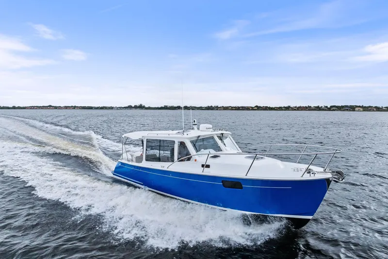 Tumalum Yacht Photos Pics 2023 MJM 35 boat cruising on open water under a clear blue sky.