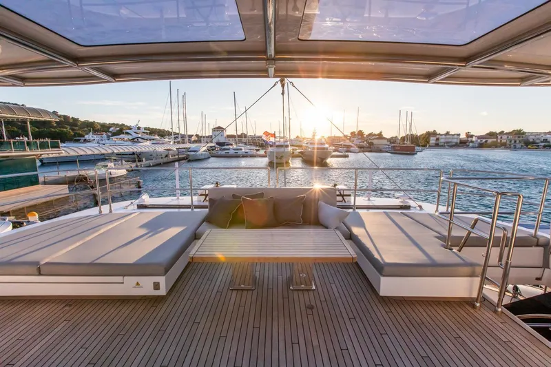 Mr.si. Yacht Photos Pics Luxurious Sunreef 60 yacht deck with sunset view, 2023 model, in a marina setting.