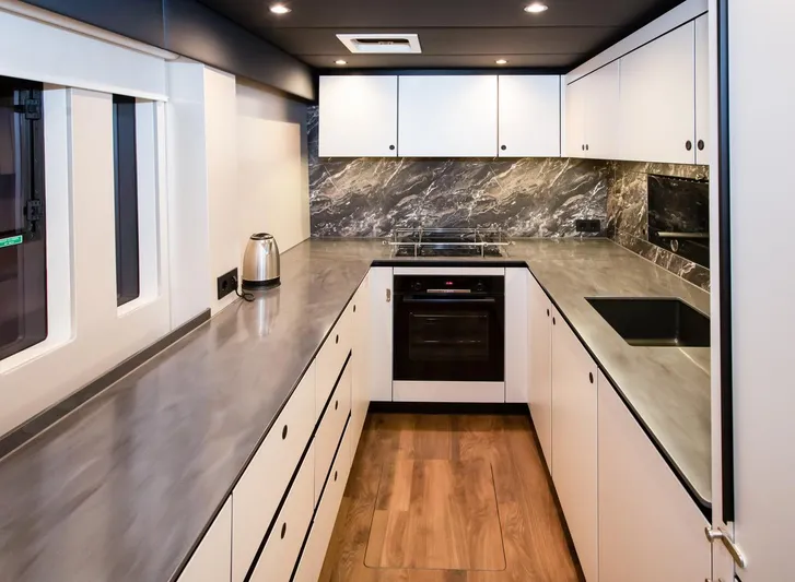 Mr.si. Yacht Photos Pics Modern kitchen interior on 2023 Sunreef 60 yacht with sleek countertops and stylish cabinetry.