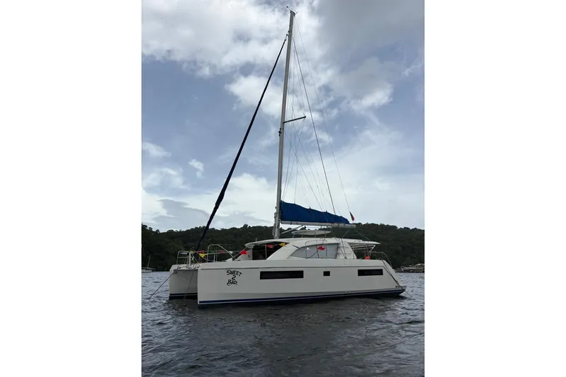 Sweet 2 Bad Yacht Photos Pics 2016 Leopard 404 catamaran with blue sails on a calm water backdrop.