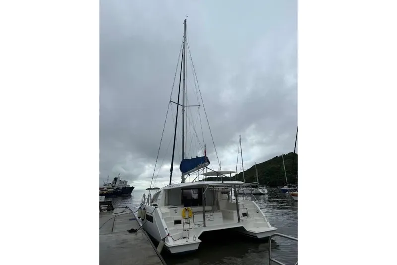 Sweet 2 Bad Yacht Photos Pics 2016 Leopard 404 catamaran docked under cloudy skies, with surrounding boats and hills.