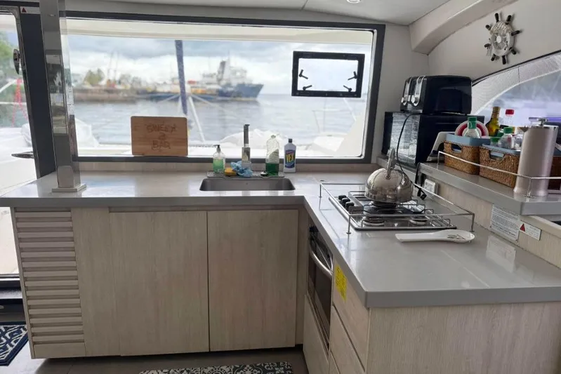 Sweet 2 Bad Yacht Photos Pics Modern kitchen interior on Leopard 404 yacht, featuring stove, sink, and ocean view.