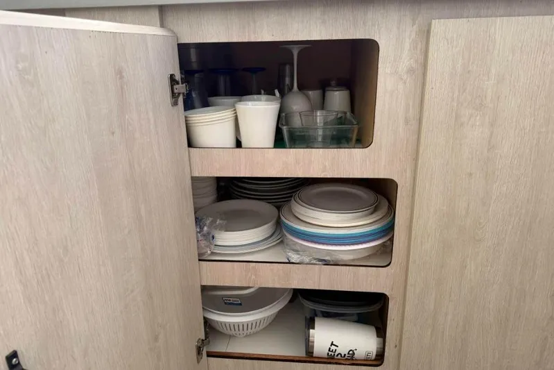 Sweet 2 Bad Yacht Photos Pics Wooden cabinet with neatly stacked dishes and cups, Leopard 404 model, 2016.