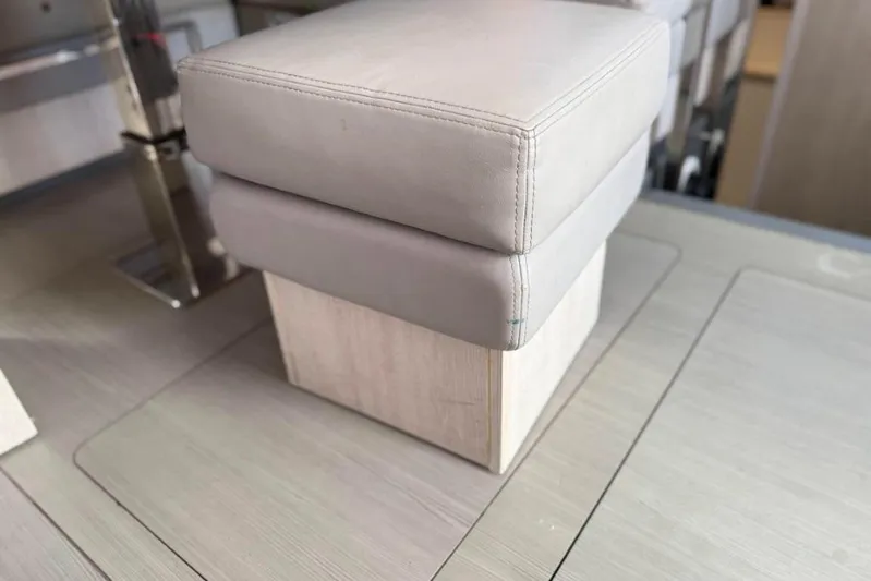 Sweet 2 Bad Yacht Photos Pics Gray cushioned seat on wooden base inside Leopard 404, 2016 model.