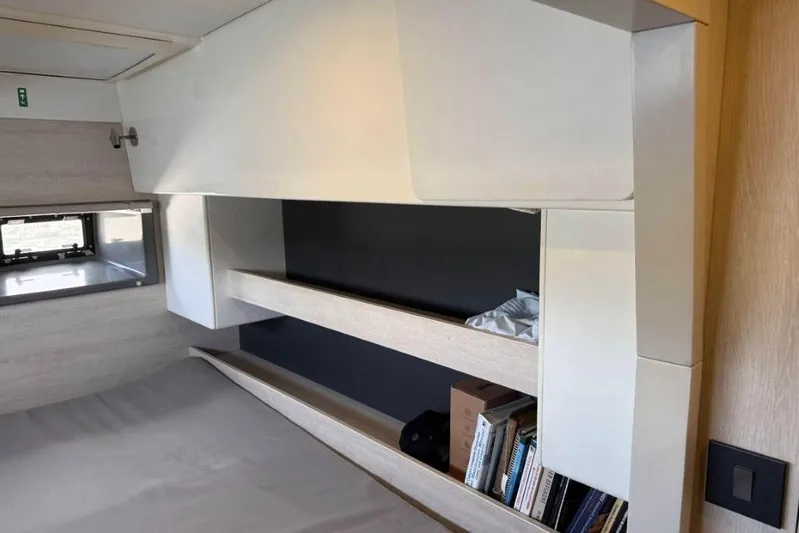 Sweet 2 Bad Yacht Photos Pics Interior of a 2016 Leopard 404 with shelves, books, and a window.