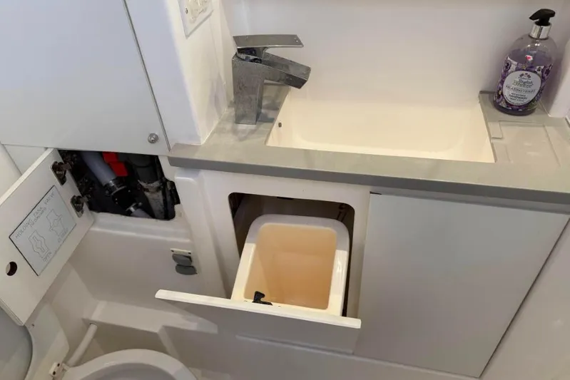 Sweet 2 Bad Yacht Photos Pics Compact bathroom sink area in a 2016 Leopard 404, featuring storage and lavender soap.