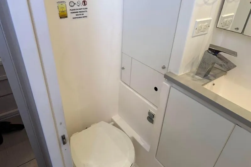 Sweet 2 Bad Yacht Photos Pics Compact bathroom in a 2016 Leopard 404, featuring a toilet and modern sink.