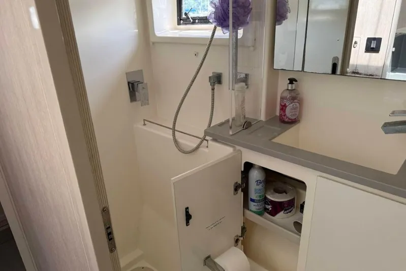 Sweet 2 Bad Yacht Photos Pics Compact bathroom in a 2016 Leopard 404, featuring a shower, sink, and storage cabinet.