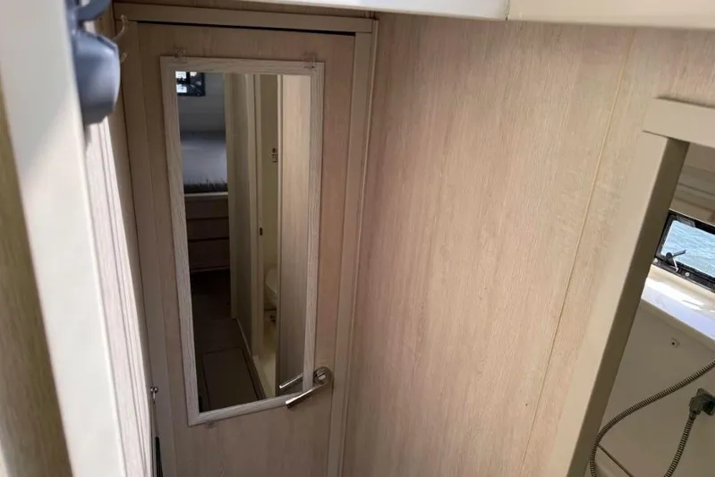 Sweet 2 Bad Yacht Photos Pics Interior of 2016 Leopard 404 showing a wooden door with mirror and adjacent window.