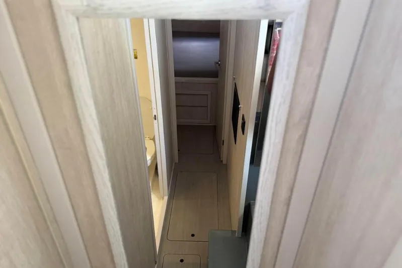 Sweet 2 Bad Yacht Photos Pics Narrow hallway inside 2016 Leopard 404 yacht, featuring light wood paneling and compact design.