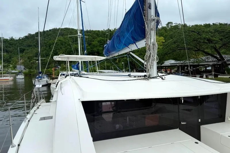 Sweet 2 Bad Yacht Photos Pics 2016 Leopard 404 catamaran docked, featuring blue sails and lush green surroundings.