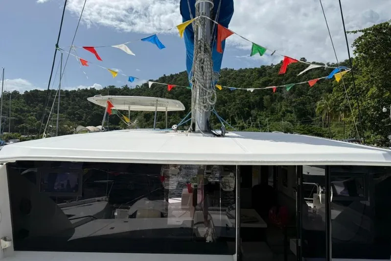 Sweet 2 Bad Yacht Photos Pics 2016 Leopard 404 catamaran with colorful flags, docked near lush greenery.