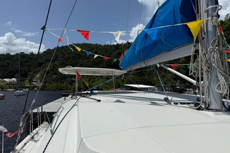 Sweet 2 Bad Yacht Photos Pics Sailboat Leopard 404 (2016) docked, adorned with colorful flags, lush greenery in background.