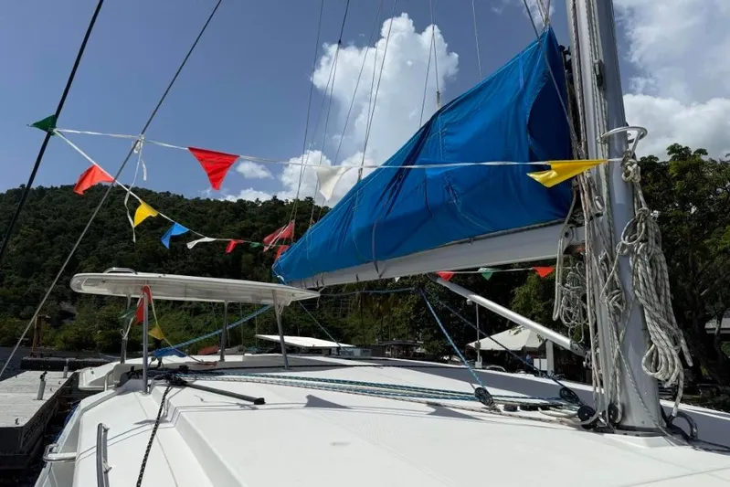 Sweet 2 Bad Yacht Photos Pics Sailboat deck with colorful flags, Leopard 404 model, 2016, against a lush green backdrop.