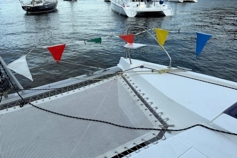 Sweet 2 Bad Yacht Photos Pics Catamaran deck with colorful flags, Leopard 404, 2016 model, moored in a marina.