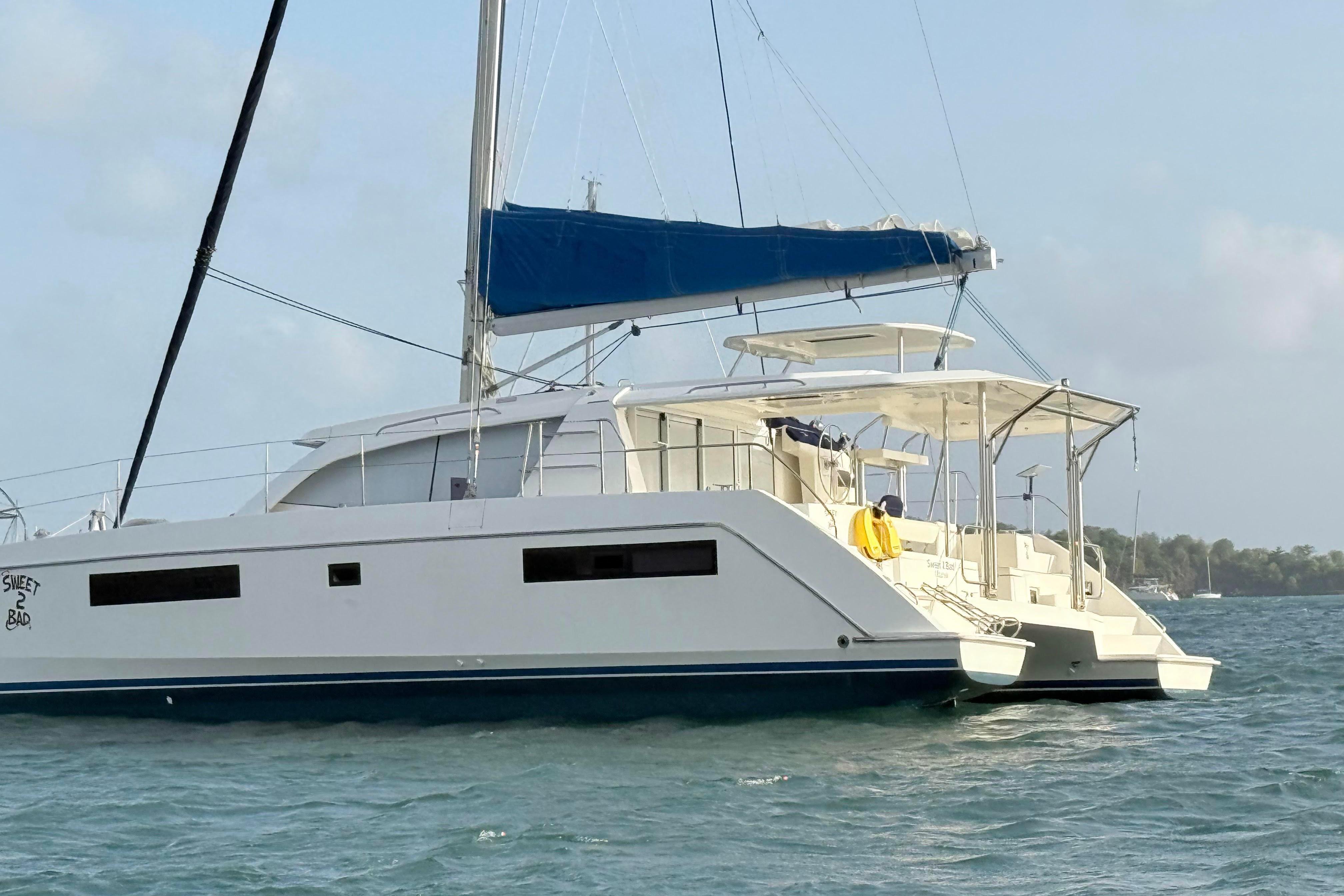 2017 Leopard 40 catamaran with blue sail, anchored on calm waters.
