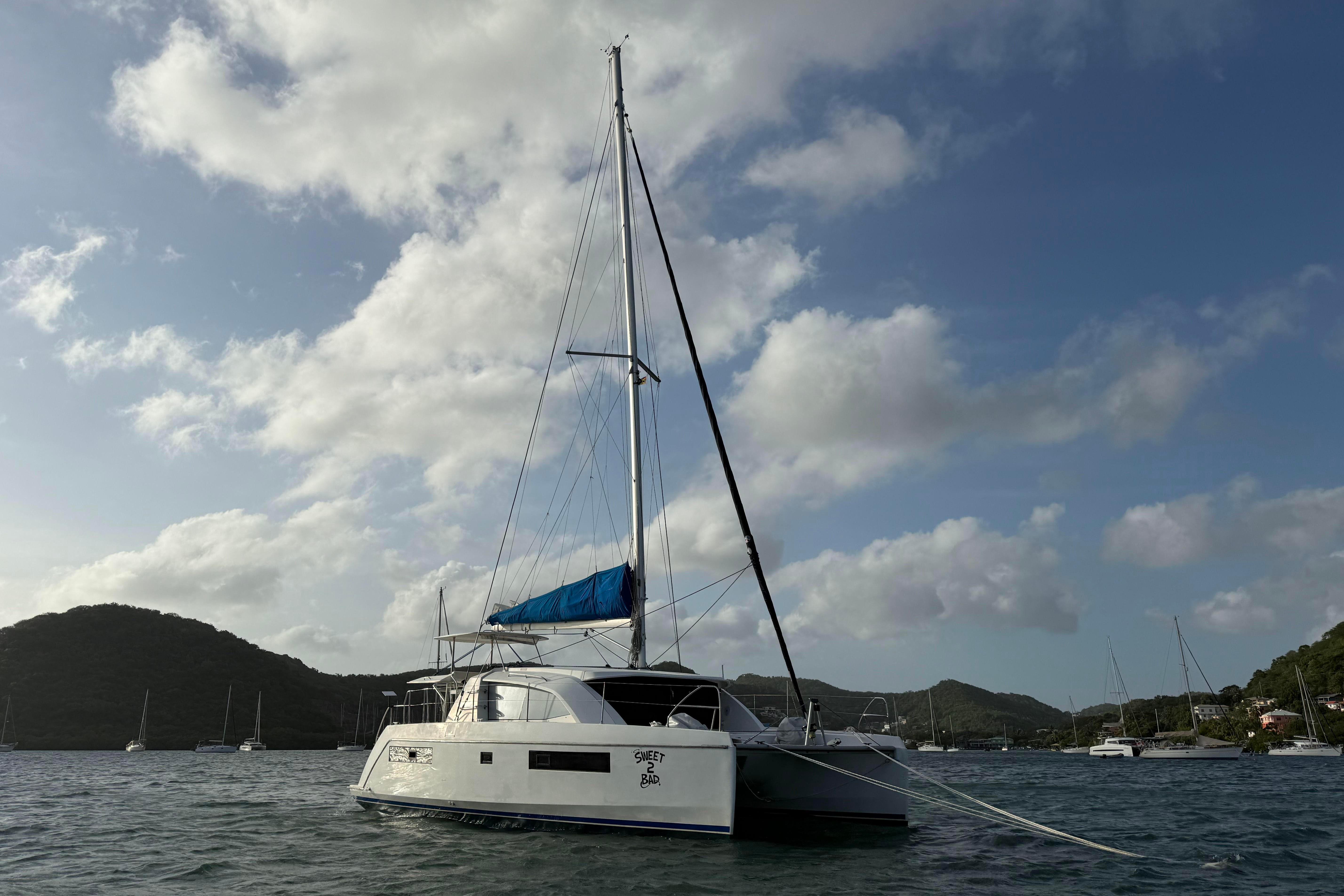 2017 Leopard 40 catamaran anchored in scenic bay under cloudy sky.