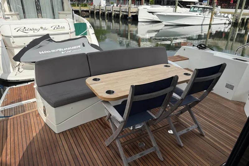 Top Nach Yacht Photos Pics Outdoor seating area on a 2017 Prestige 500S yacht with wooden deck and table.