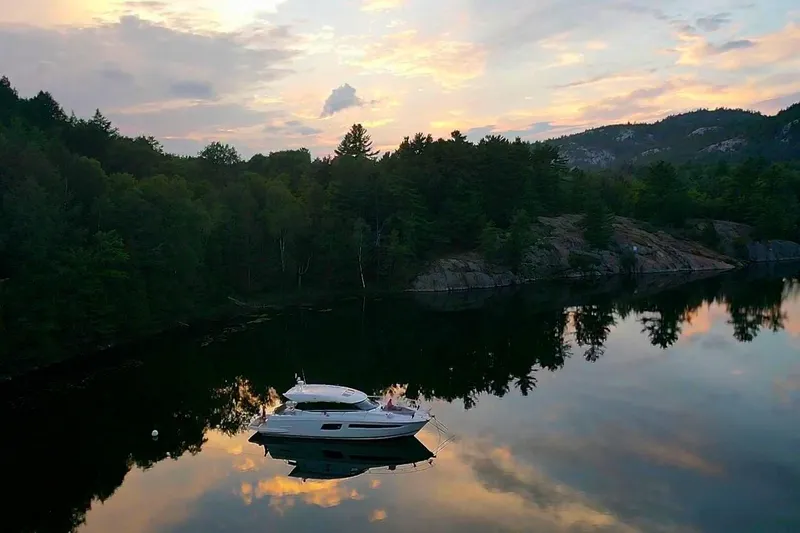 Top Nach Yacht Photos Pics Prestige 500S yacht on serene lake at sunset, surrounded by lush forest, 2017 model.