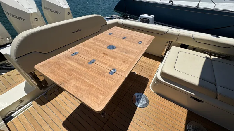 Sea Dragon Yacht Photos Pics 2023 Chris-Craft Calypso 35 boat interior with wooden table and cushioned seating.
