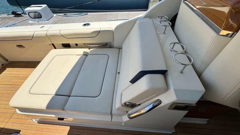 Sea Dragon Yacht Photos Pics 2023 Chris-Craft Calypso 35 boat seating area with cup holders and wooden deck.