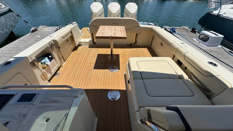 Sea Dragon Yacht Photos Pics 2023 Chris-Craft Calypso 35 boat interior with teak flooring and seating area.