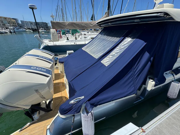 Sea Dragon Yacht Photos Pics 2023 Chris-Craft Calypso 35 with blue cover and twin Mercury engines docked at marina.