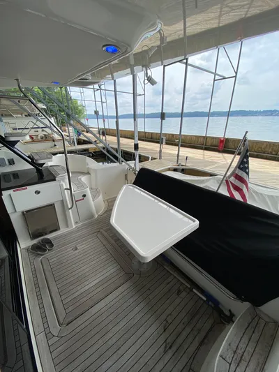 Yonder Star Yacht Photos Pics 2016 Sea Ray 510 Fly yacht deck with seating, table, and American flag by the water.
