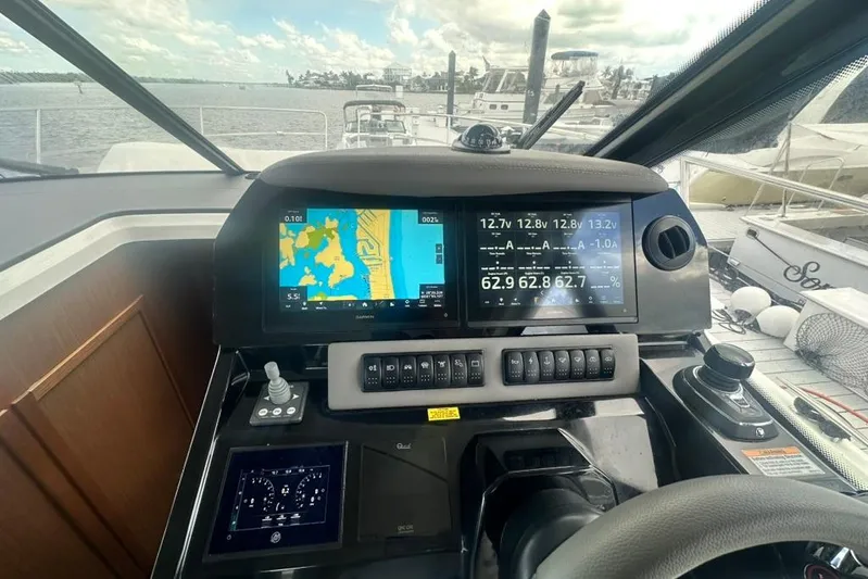  Yacht Photos Pics Cockpit of 2025 Beneteau Antares 12 with navigation screens and controls, docked at marina.