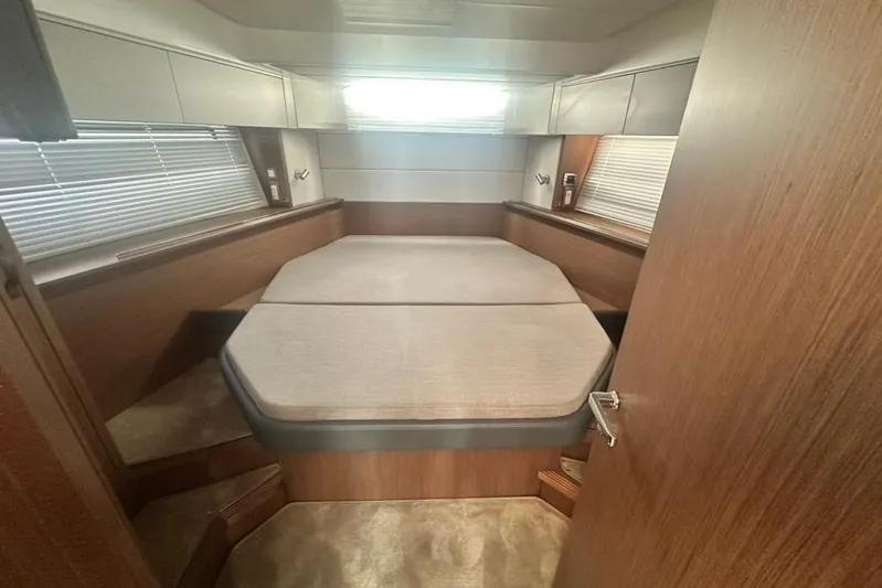  Yacht Photos Pics 2025 Beneteau Antares 12 cabin interior with cozy bed and wooden finish.