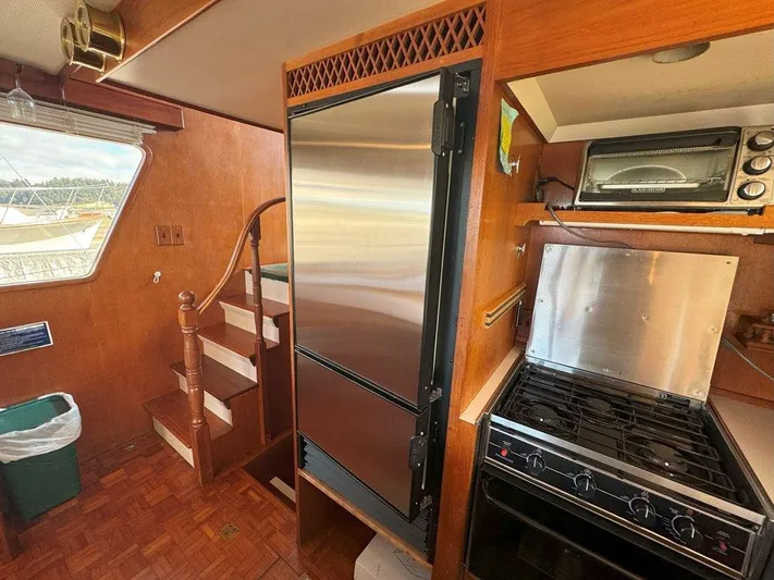 Yacht Photos Pics Interior of 1980 Ocean Alexander 50 MK1 yacht kitchen with stainless steel appliances and wooden cabinetry.