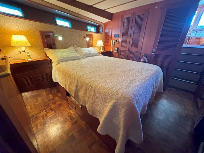  Yacht Photos Pics Cozy bedroom in 1980 Ocean Alexander 50 MK1 yacht with wooden decor and soft lighting.