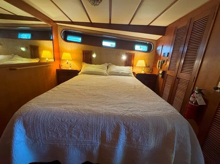  Yacht Photos Pics Cozy bedroom in 1980 Ocean Alexander 50 MK1 yacht with wood paneling and ambient lighting.