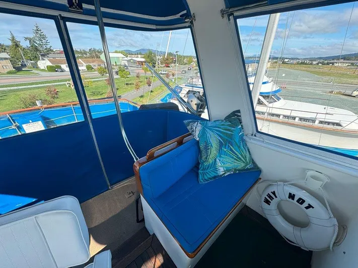  Yacht Photos Pics Interior view of 1980 Ocean Alexander 50 MK1 yacht with blue seating and scenic marina backdrop.