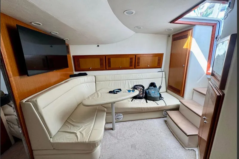  Yacht Photos Pics Interior of 2004 Cabo 40 Express Los Suenos yacht with seating, table, and TV.