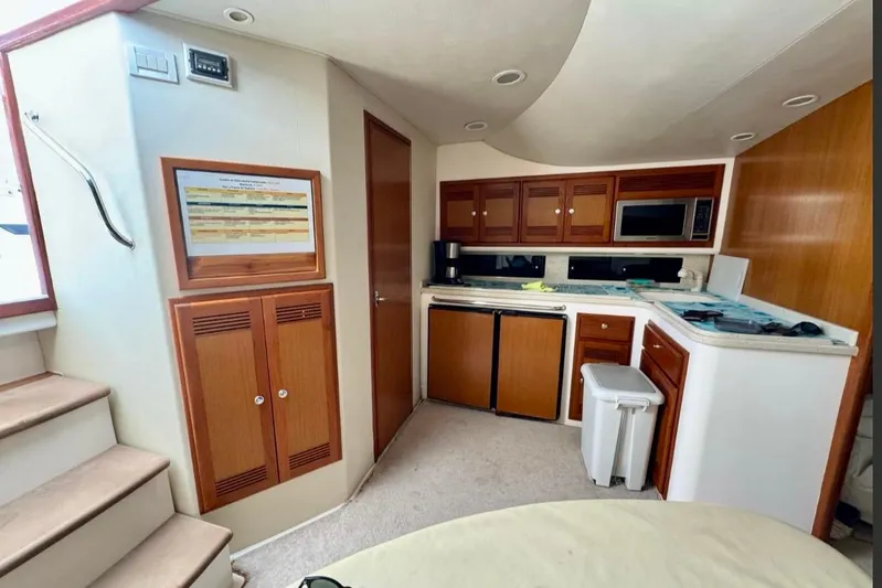  Yacht Photos Pics Interior of 2004 Cabo 40 Express Los Suenos yacht with kitchen and wooden cabinetry.