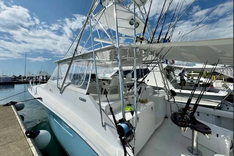  Yacht Photos Pics 2004 Cabo 40 Express Los Suenos yacht docked, featuring fishing rods and clear skies.