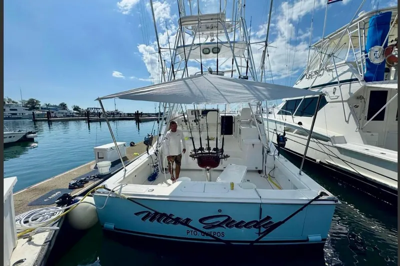  Yacht Photos Pics 2004 Cabo 40 Express Los Suenos docked at marina under clear blue sky.