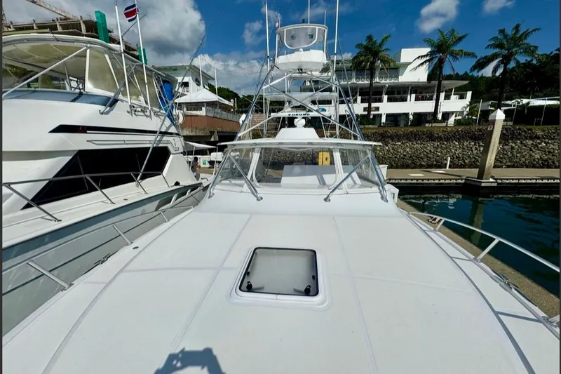  Yacht Photos Pics 2004 Cabo 40 Express Los Suenos yacht docked, with clear skies and palm trees in the background.