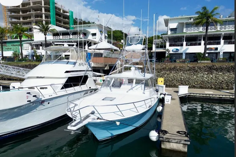  Yacht Photos Pics 2004 Cabo 40 Express Los Suenos yacht docked at marina with buildings in background.