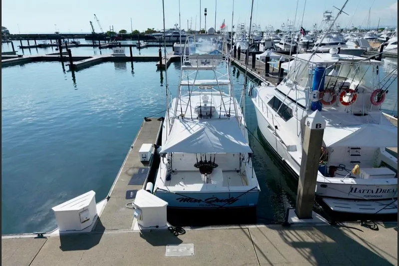  Yacht Photos Pics 2004 Cabo 40 Express Los Suenos yacht docked at marina, surrounded by other boats.