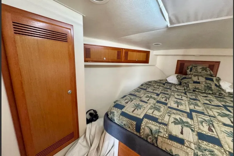  Yacht Photos Pics 2004 Cabo 40 Express Los Suenos cabin with patterned bedding and wooden storage cabinets.