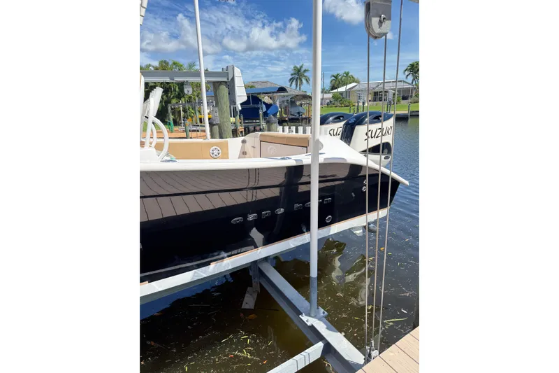  Yacht Photos Pics 2019 Cape Horn 27XS boat docked with dual Suzuki engines, under a clear blue sky.