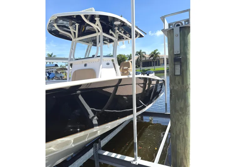  Yacht Photos Pics 2019 Cape Horn 27XS boat docked, featuring sleek black hull and T-top, under clear blue sky.
