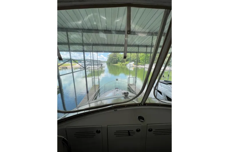  Yacht Photos Pics 2005 Carver 33 Super Sport yacht docked, viewed from the interior helm, overlooking calm waters.