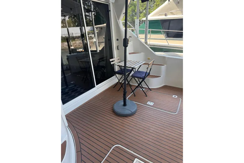  Yacht Photos Pics 2005 Carver 33 Super Sport yacht deck with table, chairs, and sliding glass doors.