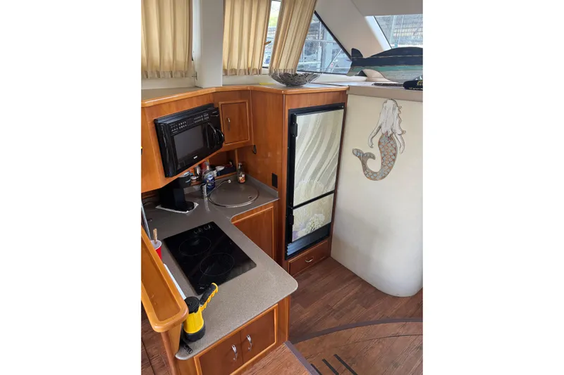 Yacht Photos Pics 2005 Carver 33 Super Sport yacht kitchen with microwave, stove, and mermaid wall art.