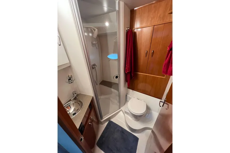  Yacht Photos Pics 2005 Carver 33 Super Sport bathroom with shower, sink, and wooden cabinetry.